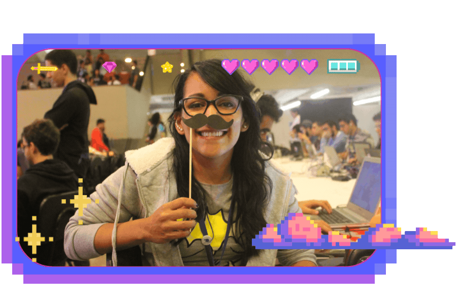 Imagem de Jusy Lopes frontal no evento de tecnologia Campus Party. Ela está segurando um bigode de papelão, adicionando um toque de humor à cena.